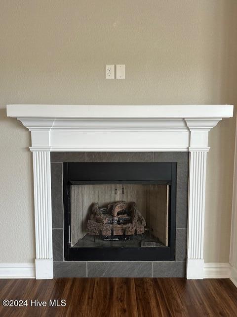 details with a tile fireplace and wood-type flooring