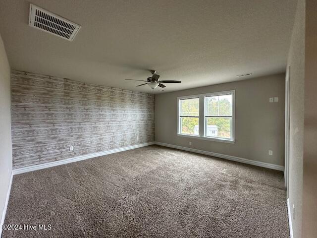 carpeted empty room featuring ceiling fan