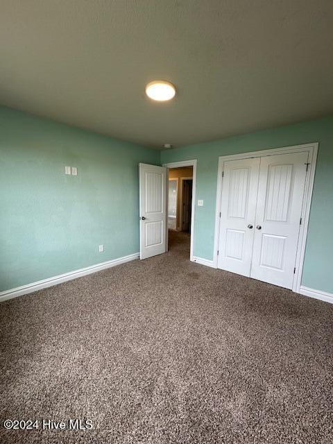 unfurnished bedroom with carpet flooring and a closet