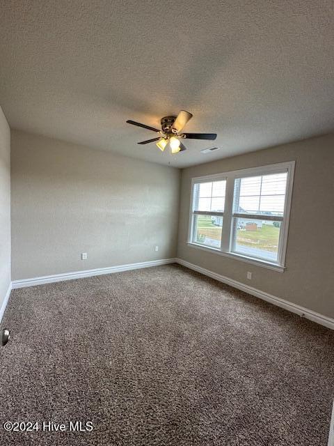 spare room featuring ceiling fan, carpet floors, and a textured ceiling