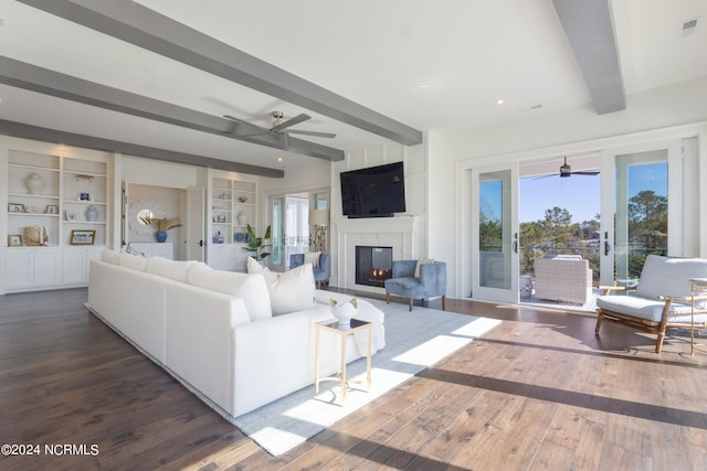 living room with beamed ceiling, dark wood-type flooring, and built in features