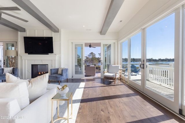 living room featuring a water view, beam ceiling, and hardwood / wood-style floors