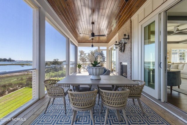 sunroom / solarium featuring a water view, wood ceiling, plenty of natural light, and ceiling fan