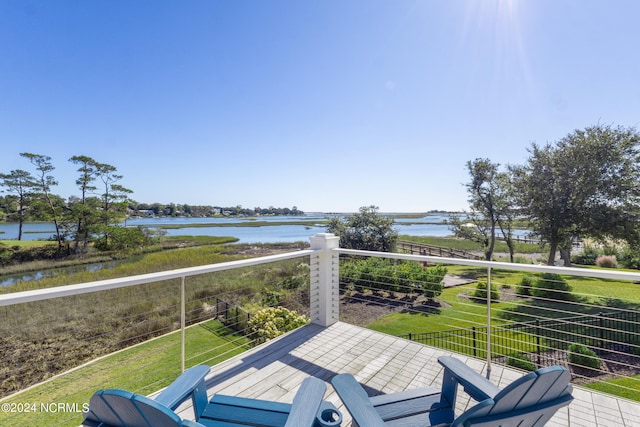 wooden deck featuring a water view and a lawn