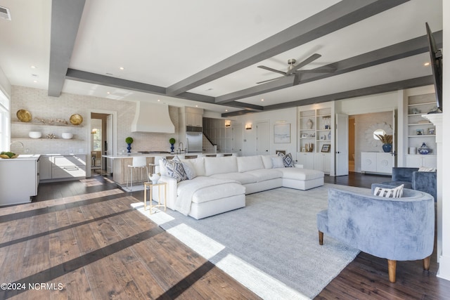 living room with beam ceiling, dark hardwood / wood-style flooring, and ceiling fan