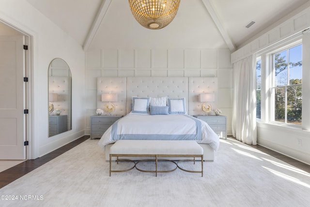 bedroom with hardwood / wood-style floors and vaulted ceiling with beams