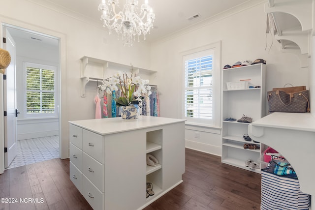 walk in closet with an inviting chandelier and dark hardwood / wood-style flooring