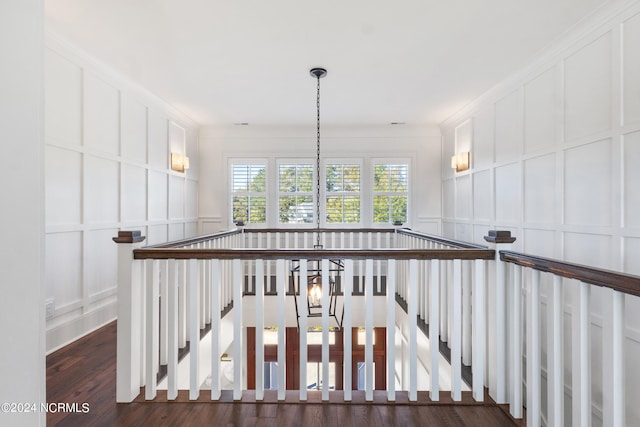 staircase featuring an inviting chandelier, hardwood / wood-style flooring, and crown molding