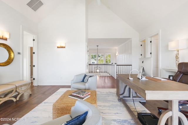 home office with high vaulted ceiling and hardwood / wood-style floors