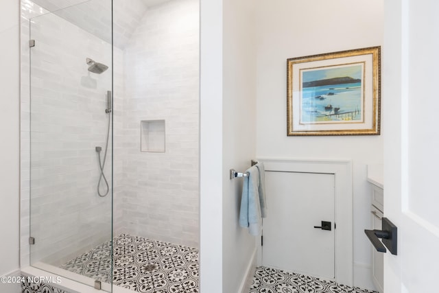 bathroom featuring vanity, a shower with shower door, and tile patterned flooring