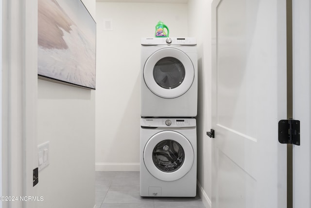 washroom featuring light tile patterned flooring and stacked washer and clothes dryer