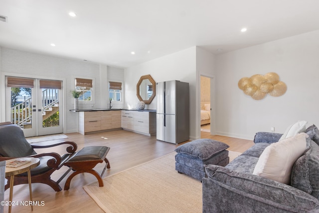 living room with french doors and light wood-type flooring