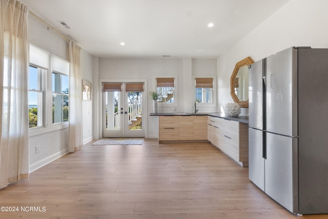 kitchen with french doors, light brown cabinets, sink, light wood-type flooring, and stainless steel refrigerator