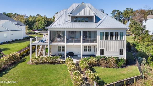 back of house featuring a patio, a lawn, and a balcony