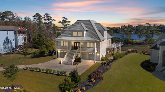 view of front of house featuring a yard, a garage, and a water view