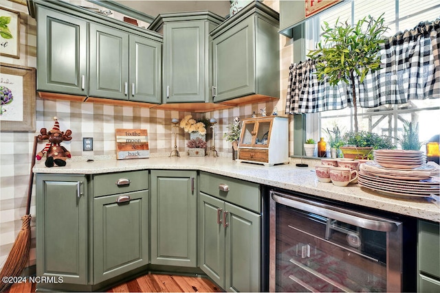 kitchen with light hardwood / wood-style floors, green cabinetry, and beverage cooler