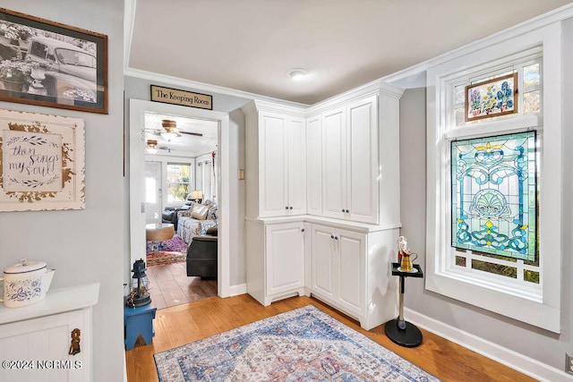 hall featuring ornamental molding and light wood-type flooring