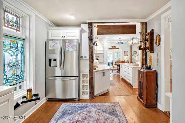 kitchen featuring light hardwood / wood-style floors, crown molding, stainless steel refrigerator with ice dispenser, and white cabinets