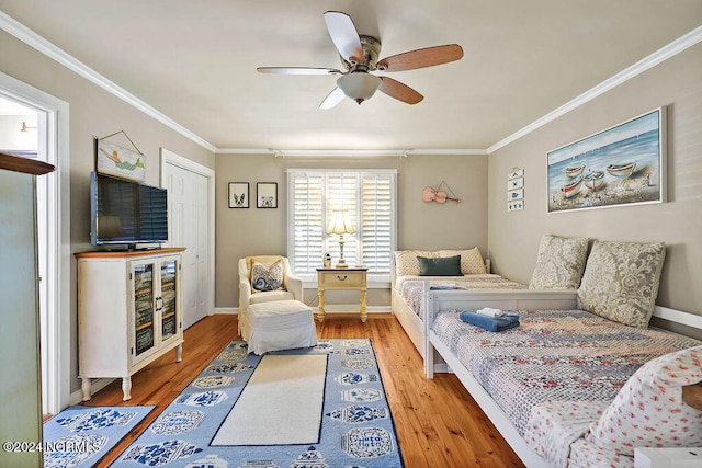 bedroom featuring a closet, ceiling fan, hardwood / wood-style flooring, and crown molding