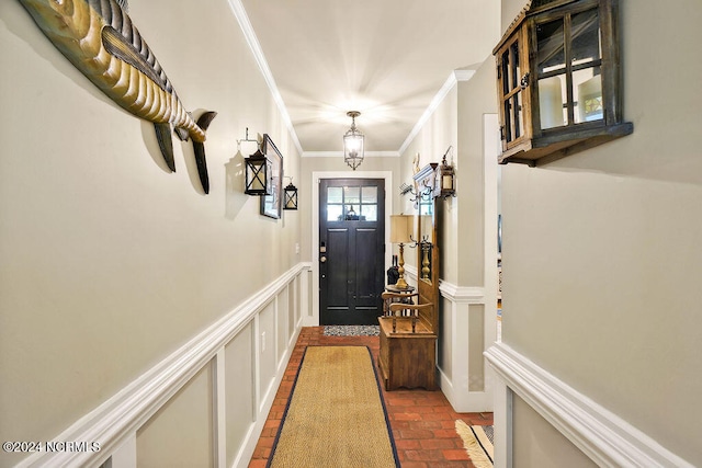 doorway featuring crown molding and a notable chandelier