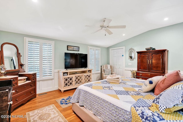 bedroom with a closet, light hardwood / wood-style floors, lofted ceiling, and ceiling fan