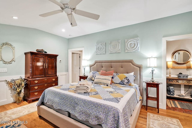 bedroom featuring light hardwood / wood-style flooring, vaulted ceiling, and ceiling fan