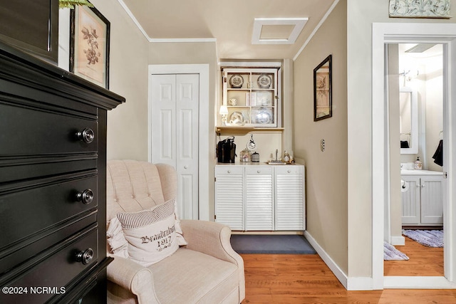 living area with hardwood / wood-style floors and crown molding