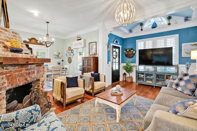 living room featuring a chandelier, a fireplace, dark wood-type flooring, and crown molding