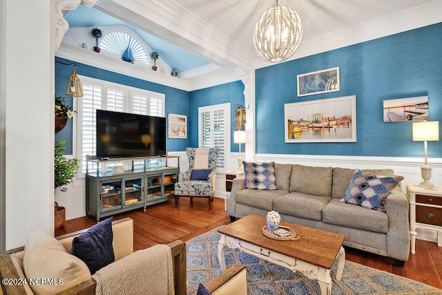 living room featuring lofted ceiling, crown molding, wood-type flooring, and a chandelier