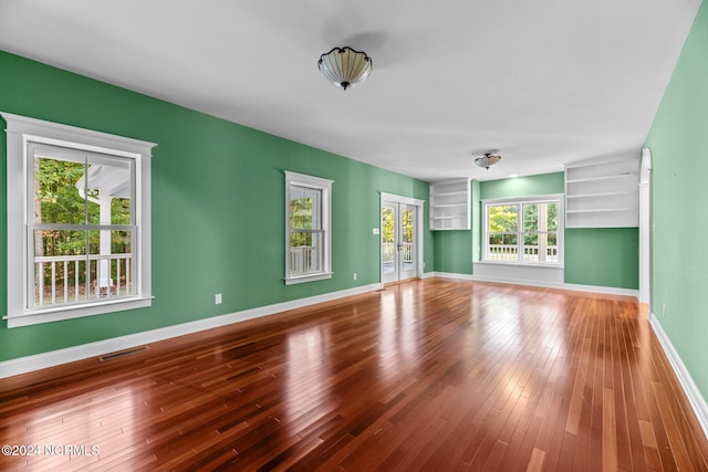 unfurnished living room with wood-type flooring and a wealth of natural light