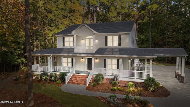 view of front of home featuring covered porch, a balcony, and a carport