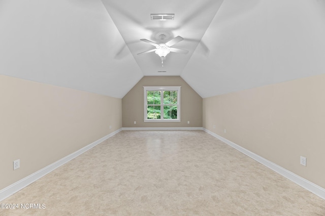 additional living space featuring light carpet, vaulted ceiling, and ceiling fan