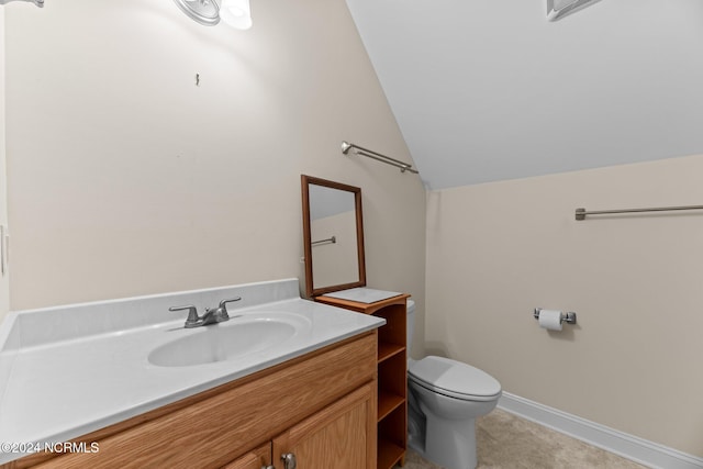 bathroom featuring vanity, lofted ceiling, and toilet