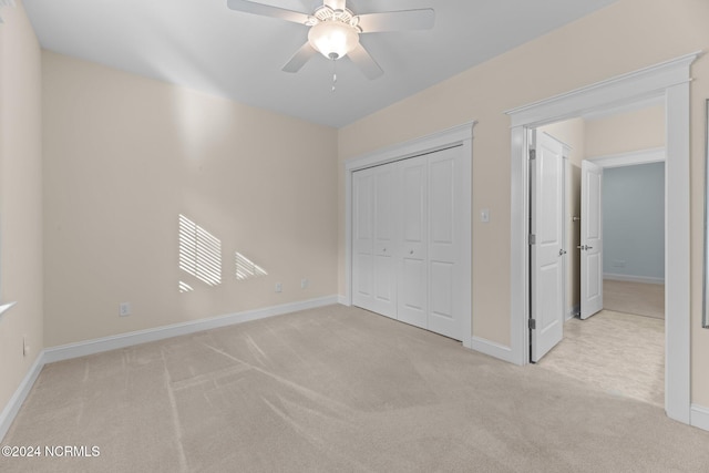 unfurnished bedroom with light carpet, a closet, and ceiling fan