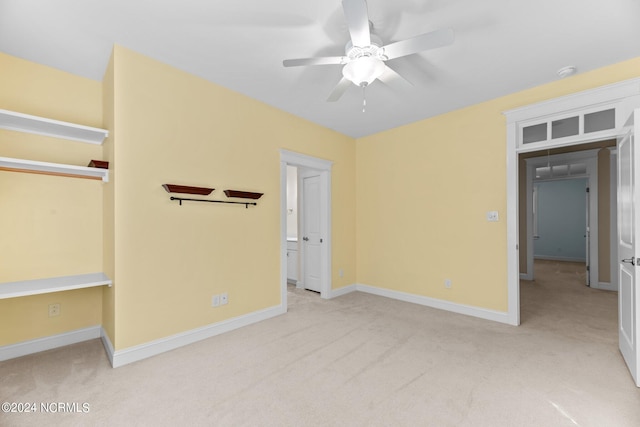 unfurnished bedroom with light colored carpet, a closet, and ceiling fan