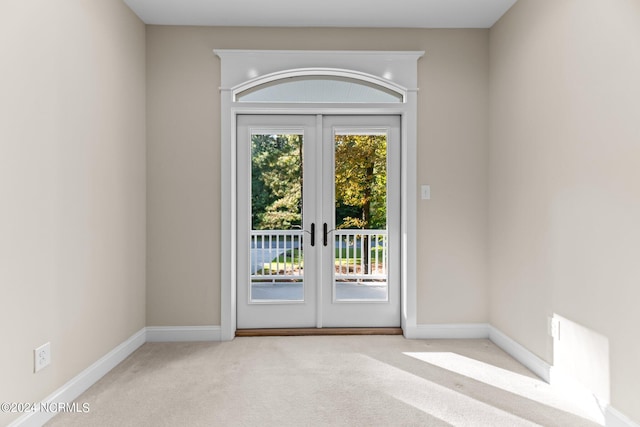 entryway with french doors and light carpet