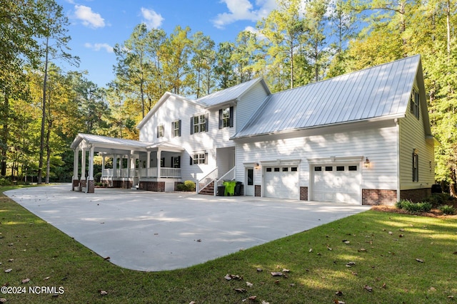 view of front of property with a garage, a front lawn, and a porch