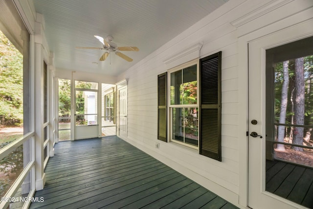 unfurnished sunroom featuring ceiling fan and a wealth of natural light