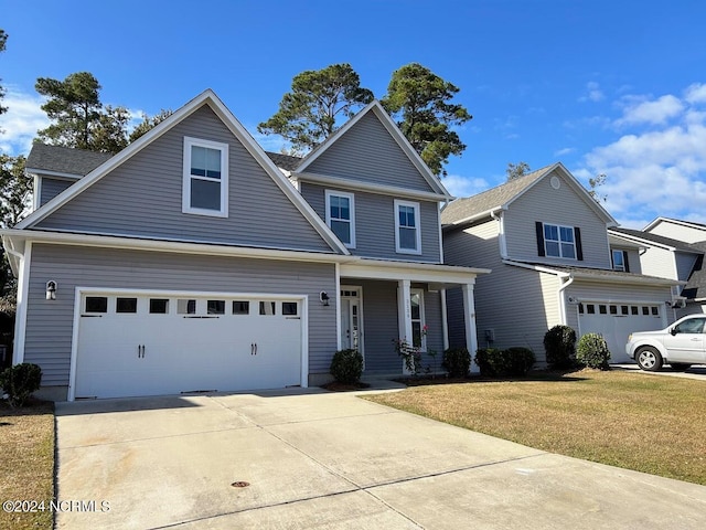 view of front of property featuring a porch, a front lawn, and a garage