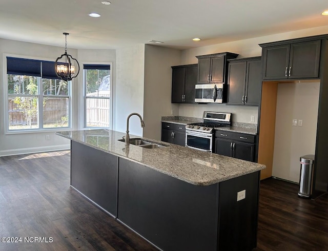 kitchen with dark wood-type flooring, appliances with stainless steel finishes, sink, and decorative light fixtures