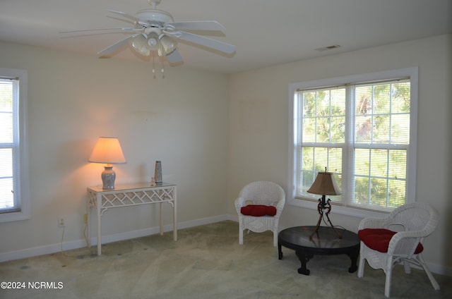 sitting room featuring a wealth of natural light, light colored carpet, and ceiling fan