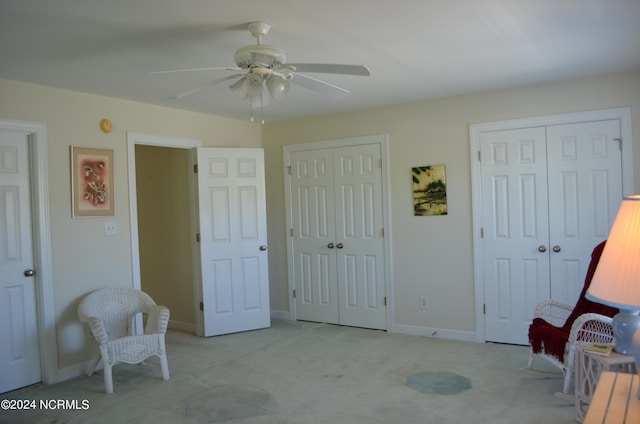 living area with light colored carpet and ceiling fan