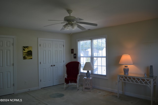 living area featuring ceiling fan and carpet flooring