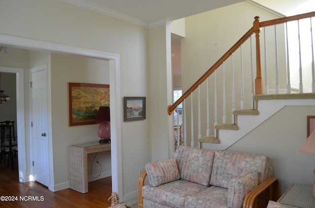 stairs with ornamental molding and hardwood / wood-style floors