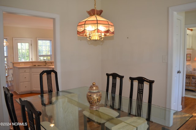 dining area featuring light hardwood / wood-style flooring, sink, and a notable chandelier