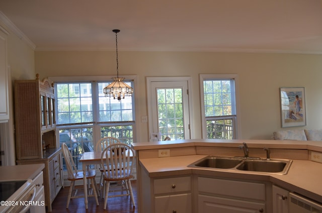 kitchen with dishwasher, sink, decorative light fixtures, white cabinets, and ornamental molding