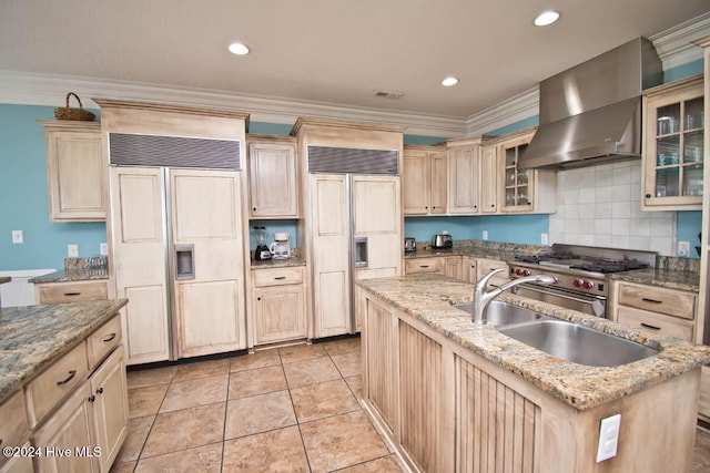 kitchen with light brown cabinetry, wall chimney exhaust hood, ornamental molding, and high end appliances