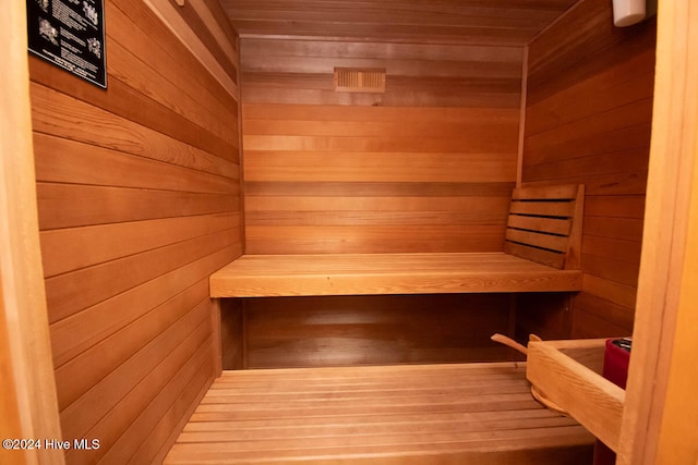 view of sauna featuring wooden ceiling, wood-type flooring, and wooden walls