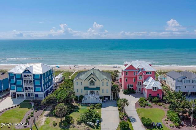 birds eye view of property with a water view and a beach view