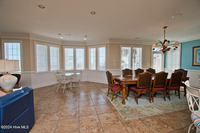 tiled dining room featuring a wealth of natural light, crown molding, and an inviting chandelier